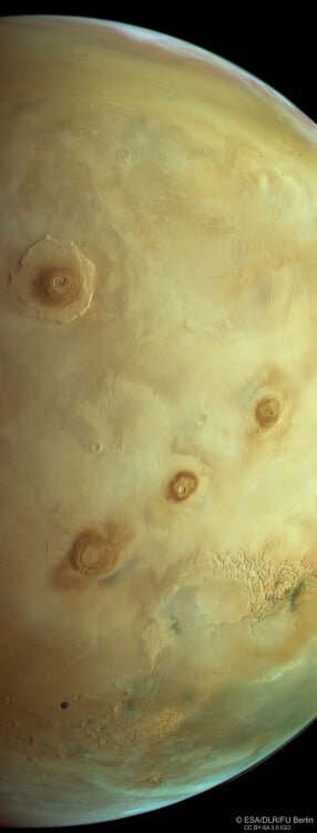 The Mars Express view of Mars, with colossal volcanoes, clouds, craters, and a photobomb from a moon.