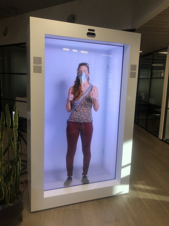 The author wearing maroon pants stands in a white box with thumbs up.